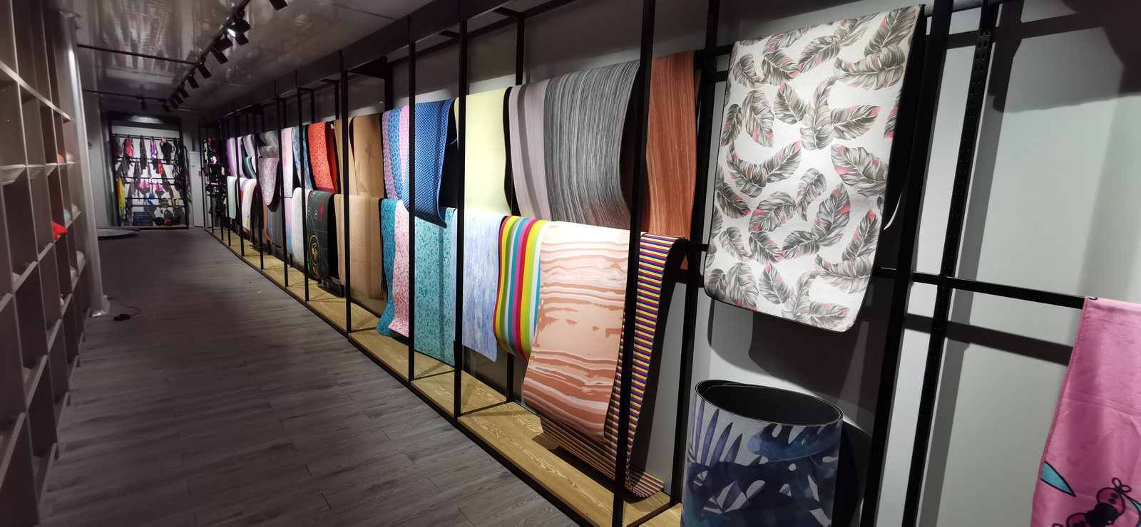 Sample wall of custom printed yoga mats in the factory showroom